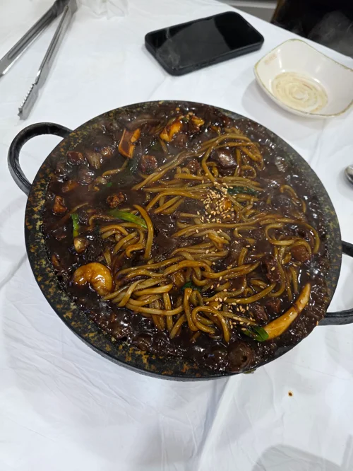 가보오토종닭 해물돌짜장 - 검은 돌판 위 윤기 나는 짜장면과 해물