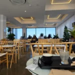 밝은 간접조명과 원목 테이블이 있는 모던한 카페 내부