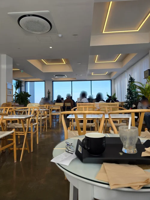 밝은 간접조명과 원목 테이블이 있는 모던한 카페 내부