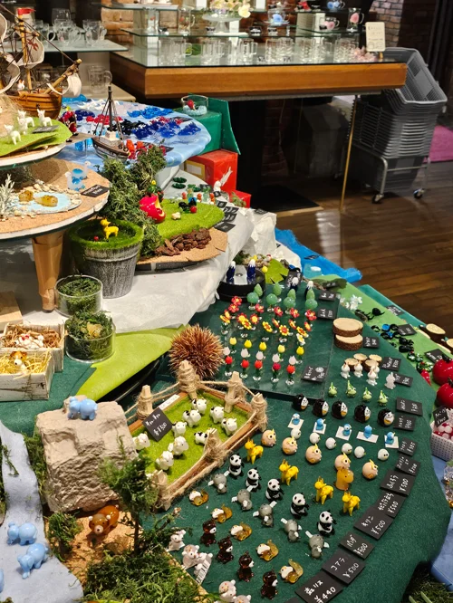 녹색 펠트 위에 동물 미니어처와 목재 소품으로 꾸민 농장 디오라마 작품