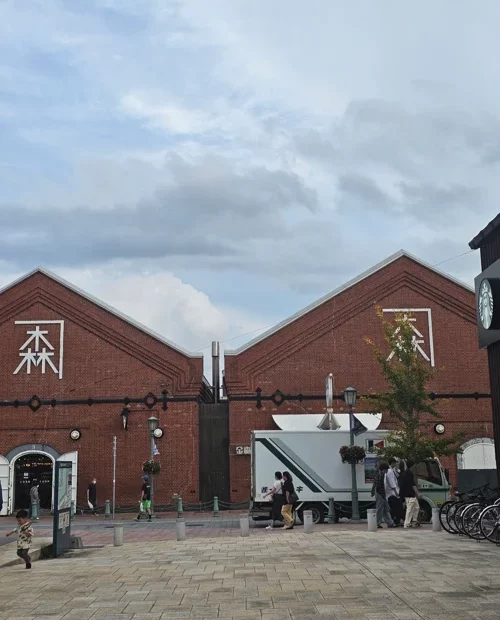 붉은 벽돌로 지어진 가네모리 레드 브릭 웨어하우스 건물 전경과 중앙 광장