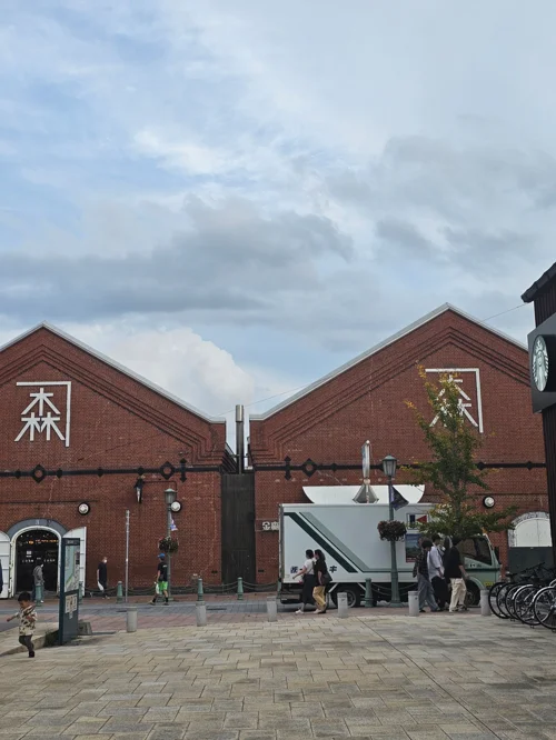 붉은 벽돌로 지어진 가네모리 레드 브릭 웨어하우스 건물 전경과 중앙 광장