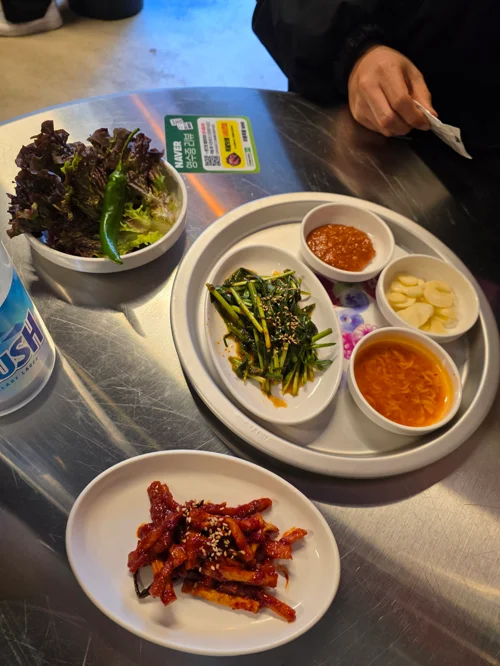 무등족발 기본 반찬 세팅, 쌈채소 부추무침 쌈장 마늘 양파절임이 트레이에 담겨있고 무말랭이 무침이 따로 나왔다