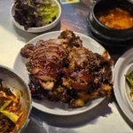 통깨가 뿌려진 족발과 쌈채소, 김치찌개 등 밑반찬이 차려진 한식 상차림