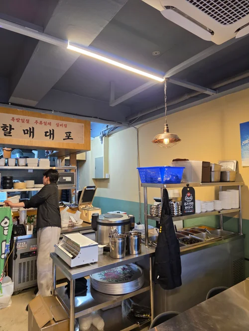 무등족발 주방 내부, 할매대포 간판이 보이고 직원이 조리 중이다