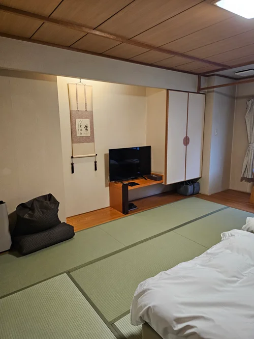 다다미가 깔리고 족자와 TV가 있는 일본 전통 료칸 객실 내부