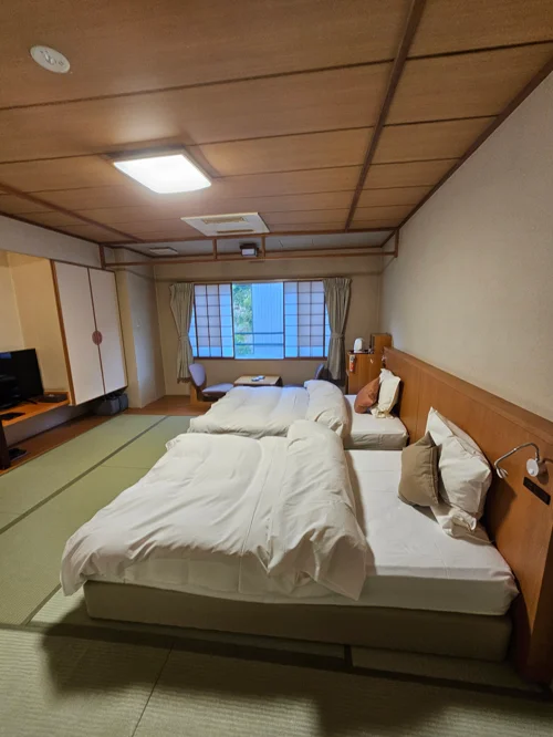 다다미 바닥에 트윈 베드가 놓인 넓은 타키노야 케칸 타마노유 트윈룸 객실