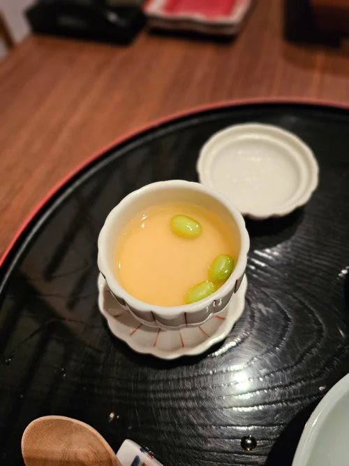 검은 트레이 위 흰 도자기 그릇에 담긴 일본식 달걀찜 차완무시