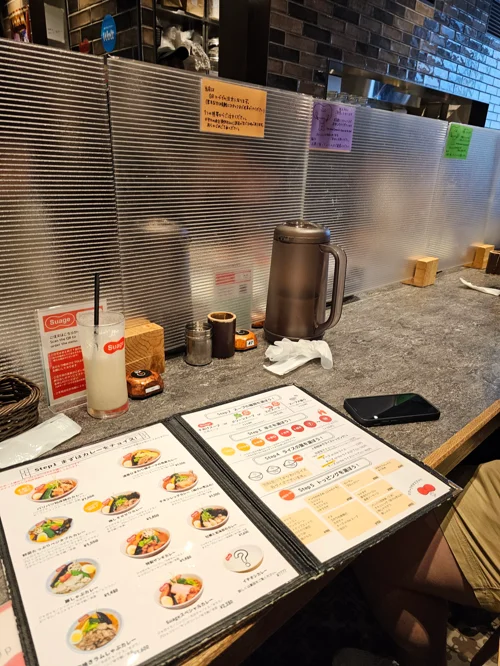 일본 음식점 카운터석에 놓인 메뉴판과 레몬 음료