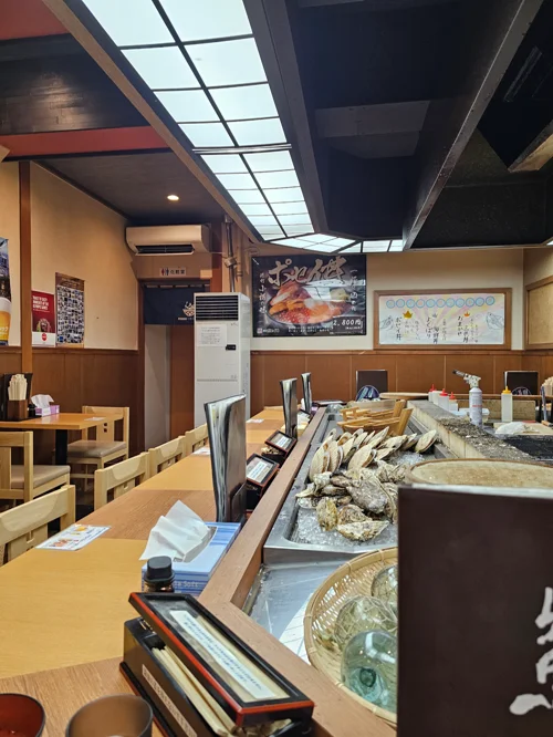 신선한 굴이 카운터에 진열된 일본 전통 해산물 식당 내부 모습