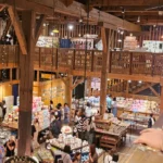 목조 2층 구조의 홋카이도 기념품 쇼핑몰 내부에 관광객들이 쇼핑하는 모습