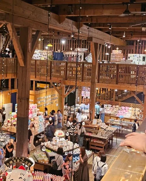 목조 2층 구조의 홋카이도 기념품 쇼핑몰 내부에 관광객들이 쇼핑하는 모습