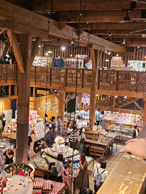목조 2층 구조의 홋카이도 기념품 쇼핑몰 내부에 관광객들이 쇼핑하는 모습