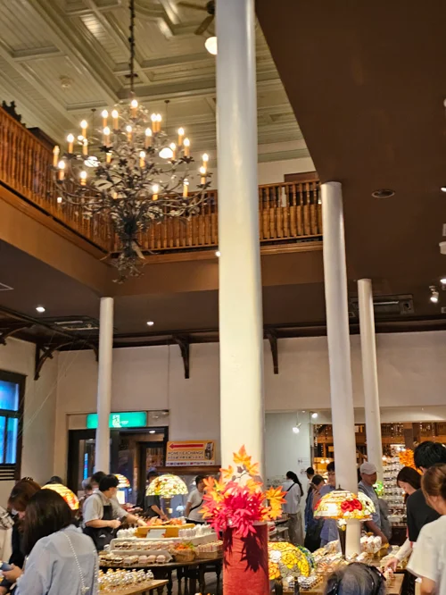 샹들리에와 흰 기둥이 있는 클래식한 2층 베이커리 내부 모습