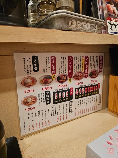 일본 라멘 가게 카운터의 메뉴판으로 미소·마제소바 등 880~950엔 메뉴가 나열된 모습