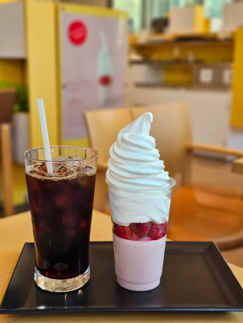 검은 트레이 위에 딸기 소프트아이스크림과 아이스 아메리카노가 나란히 놓인 카페 디저트 세트