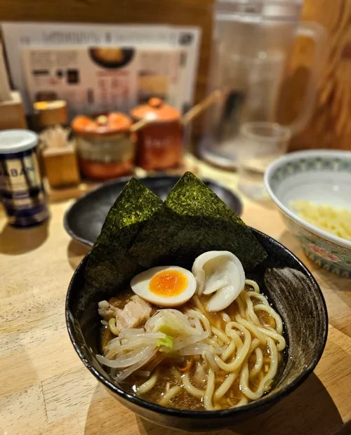 검은 그릇에 담긴 김과 반숙 달걀이 올려진 일본식 라멘