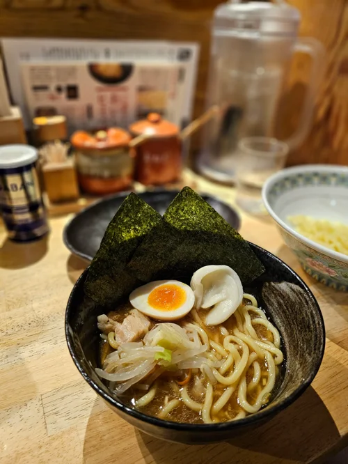 검은 그릇에 담긴 김과 반숙 달걀이 올려진 일본식 라멘