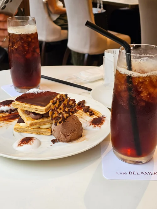 카페벨라메 흰 접시에 담긴 초콜릿 밀크레이프와 아이스크림, 아이스 아메리카노 두 잔