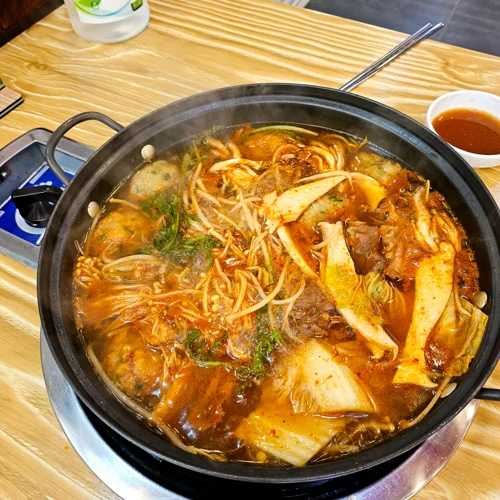 다양한 채소와 어묵 고기가 들어간 얼큰한 한국식 전골이 냄비에 끓고 있는 모습