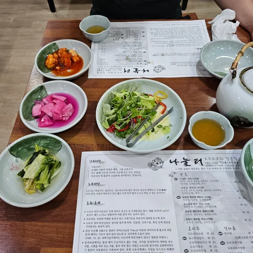 한국 전통 식당 나눌터의 식탁에 차려진 다양한 반찬과 차 세팅