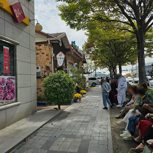한국 상가 거리 인도에서 식당 앞 대기줄을 서고 있는 사람들