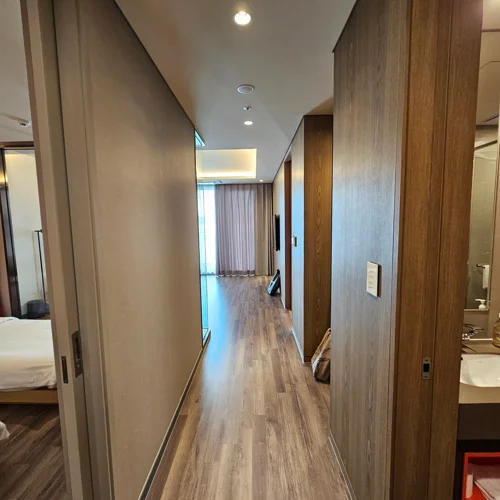 우드 마감재와 매립 조명으로 꾸며진 여수 벨메르 호텔 객실 복도