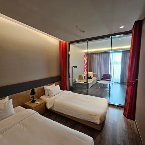 여수 벨메르 호텔 객실 내부 트윈베드와 레드 커튼 인테리어