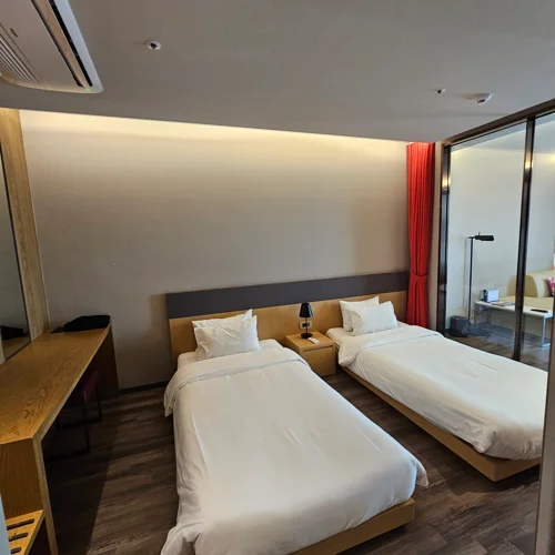 여수 벨메르 스탠다드 트윈 오션뷰 객실 트윈베드와 유리 파티션