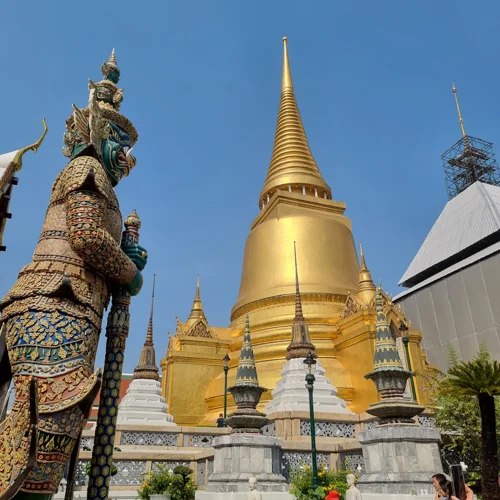 방콕 왓 프라깨우 경내의 황금 체디와 좌측 야차 수호신 조각상