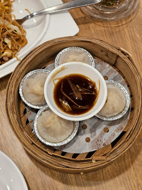 대나무 찜기에 담긴 샤오룽바오와 생강 간장 소스