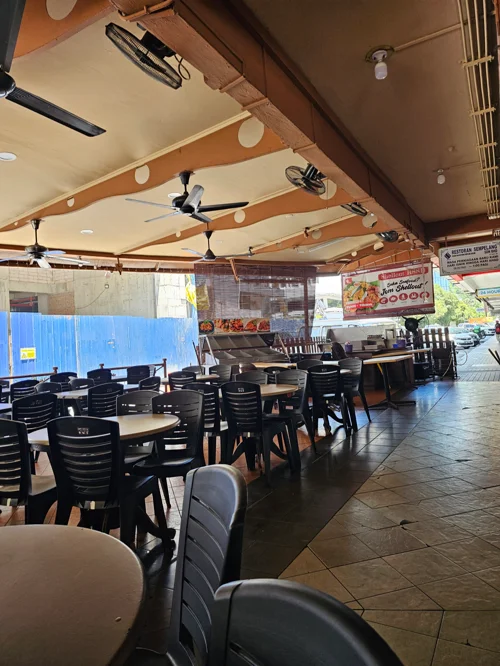 천장 선풍기와 검정 의자가 줄지어 있는 코타키나발루 샘플랑 레스토랑 내부